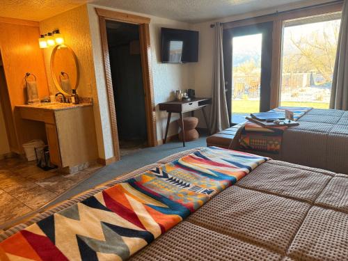 a bedroom with a bed with a colorful blanket on it at Ninepipes Lodge in Polson