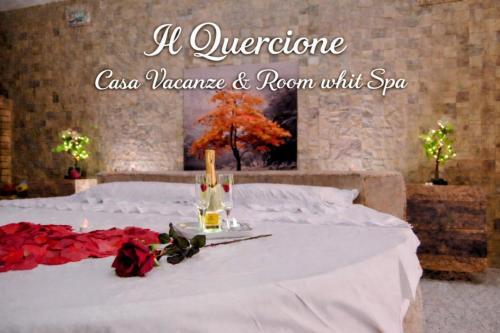 a bed with a bottle of champagne and roses on it at "Il Quercione" Room With SpA in Lama Di Peligni