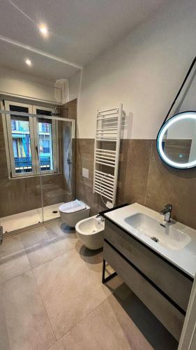 a bathroom with two sinks and a toilet and a shower at Boutique Apartments Magenta in Magenta