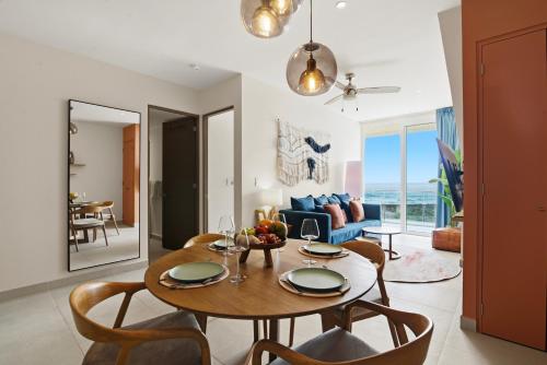 a dining room and living room with a table and chairs at Ocean View Haven Walk to Beach Private Rooftop Terrace in Akumal
