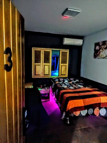 a bedroom with two beds and a window with purple lights at Panorâmic Luxo Exclusiv in Santa Cruz Cabrália