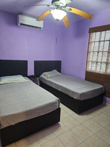a bedroom with two beds and a ceiling fan at Casa Quinta Real in Cedro