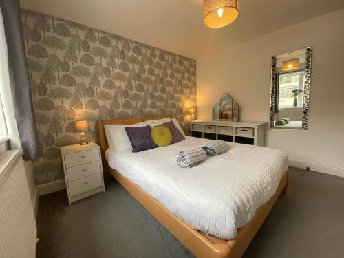 a bedroom with a bed and two lamps and a mirror at Mill Lane Holiday Cottage -Bath in Bath