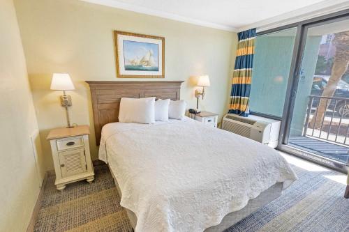 a bedroom with a bed and a large window at New Oceanview, Low Floor, Heated Pools! in Myrtle Beach