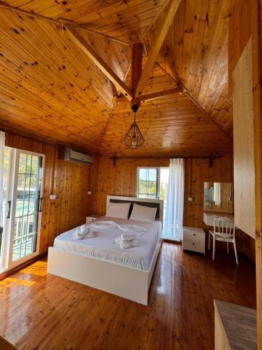 a bedroom with a large bed in a wooden room at The White Troy in Sarandë