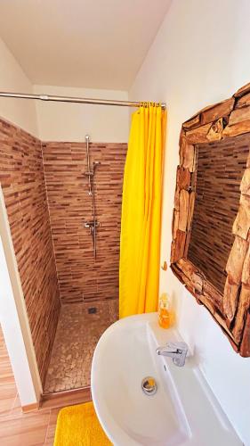 a bathroom with a shower and a white sink at Bungalow Soleil Sainte-Anne - Plage à pied in Sainte-Anne