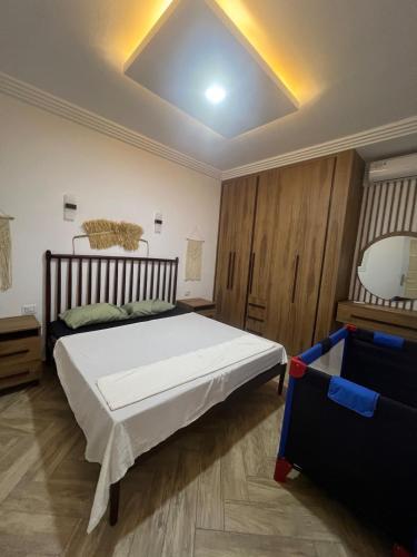 a bedroom with a large white bed and a mirror at Maison des 5 palmiers in Taguermess