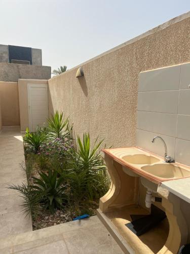 a bathroom with a sink next to a building at Maison des 5 palmiers in Taguermess