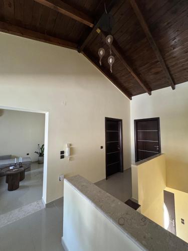 a living room with white walls and a wooden ceiling at TheraLiving - Boutique Apartment with Balcony in Afantou