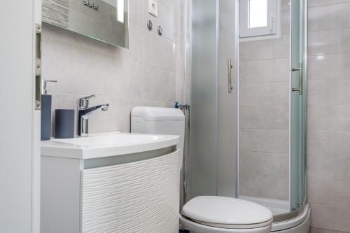 a bathroom with a toilet and a sink and a shower at Camp Panorama with pool in Drage