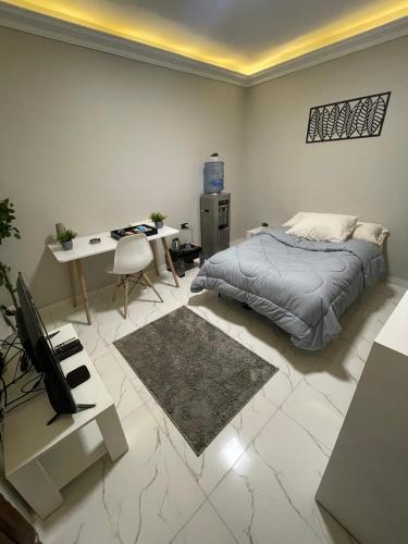 a bedroom with a bed and a desk with a computer at Sharo's House in Cairo