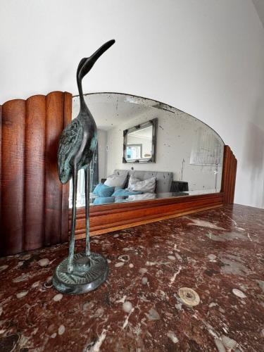 a statue of a bird standing in front of a mirror at Panorama Joy - stilvolle Gemütlichkeit mit Weitblick in Schmallenberg