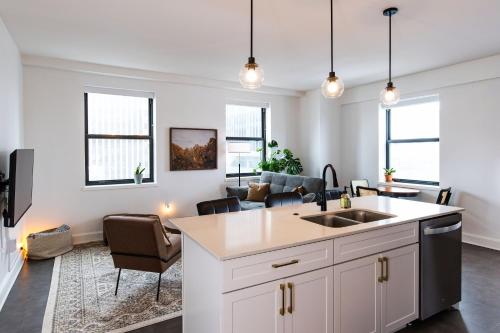 a kitchen with a sink and a living room at Luxury Downtown Apt with Parking, Gym, and Lap Pool in Milwaukee
