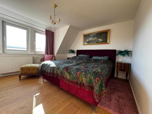 a bedroom with a large bed and a chandelier at Panorama Joy - stilvolle Gemütlichkeit mit Weitblick in Schmallenberg