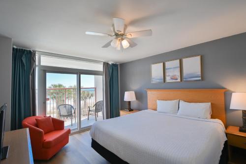 a bedroom with a bed and a chair and a window at A Piece of Paradise, Newly Renovated in Myrtle Beach