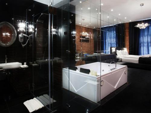 a bathroom with a shower and a sink and a tub at Hotel Betmanowska Main Square Residence Adults Only in Kraków