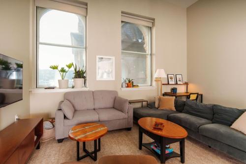 a living room with a couch and a table at Downtown Luxe 2BR Loft Apt | Sleeps 8 | Walkable in Milwaukee