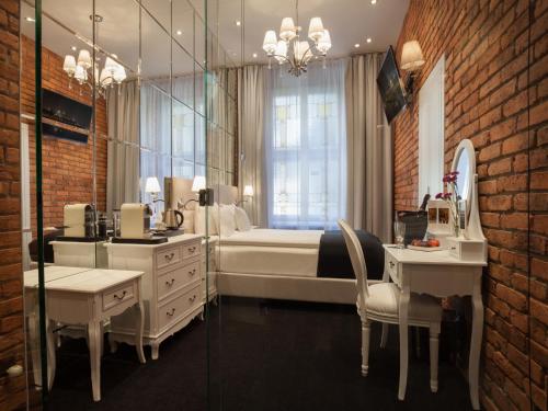 a bedroom with a bed and a vanity and a mirror at Hotel Betmanowska Main Square Residence Adults Only in Kraków