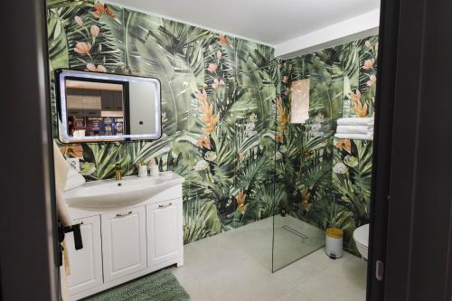 a bathroom with a sink and a leafy wallpaper at Cabana Almora in Dorna Arini