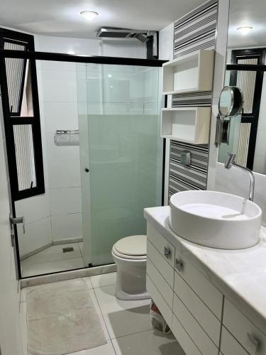 a bathroom with a toilet and a sink and a shower at Enseada do Suá Golden Gate - Moderno e Espaçoso in Vitória