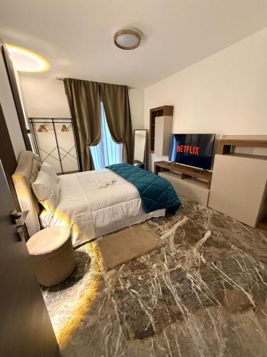 a hotel room with a bed and a television at DyAndy Suites Expo Milano in Baranzate