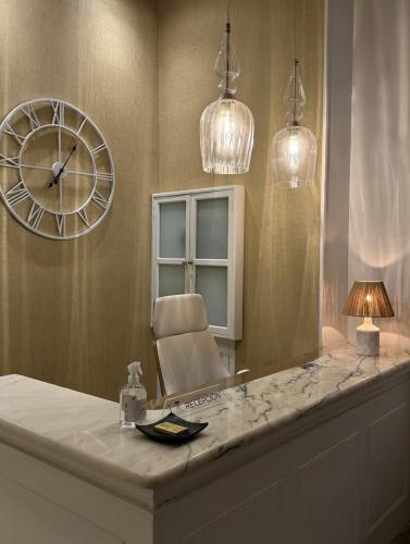 a large mirror with a chair and a clock at Cuatro Caminos Rooms in Torrelavega
