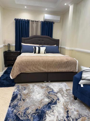 a bedroom with a large bed and a rug at Lumiere Suites in Georgetown