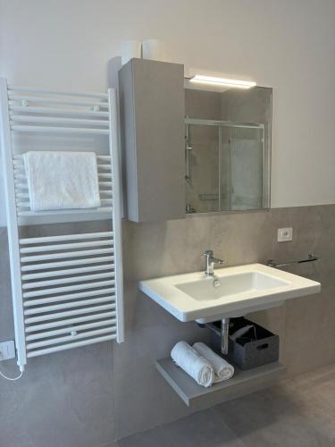 a bathroom with a sink and a mirror and towels at Matilde Apartments Caorle in Caorle