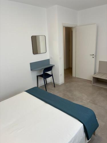 a bedroom with a white bed and a desk at Matilde Apartments Caorle in Caorle