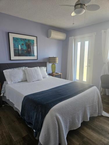 a bedroom with a large bed with a blue wall at Global Village Permaculture BnB in Oliver