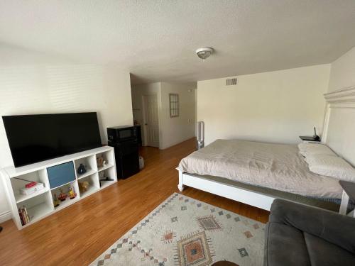 a bedroom with a bed and a flat screen tv at LA Lux Suite with Private Bathroom in Santa Clarita