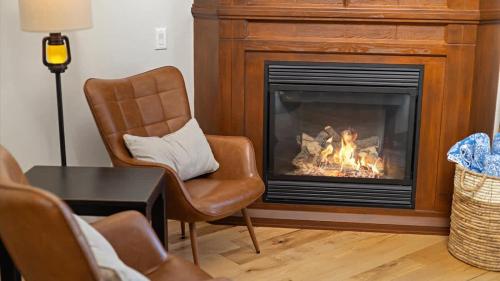a living room with a fireplace and two chairs at Altitude Adjustment in Red Lodge