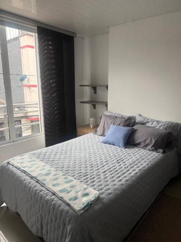 a bedroom with a large bed with a window at En el corazon de Dosquebradas in Dosquebradas