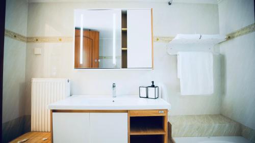 a bathroom with a white sink and a mirror at Vignetta Mare 2BR Villa με Θέα & και Ιδιωτικό Πάρκινγκ in Ermoupoli