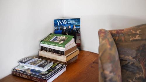 a stack of books sitting on a table next to a couch at Grizzly Grotto in Red Lodge