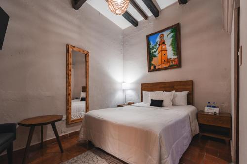 a bedroom with a large bed and a mirror at Te Amo Hotel Boutique in San Miguel de Allende