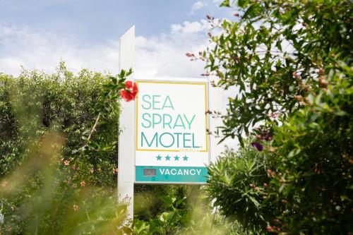 a sign that says see a spray model in a garden at Sea Spray Motel - Merimbula in Merimbula