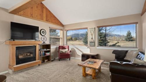 a living room with a fireplace and a tv at Sans Souci Cabin in Red Lodge