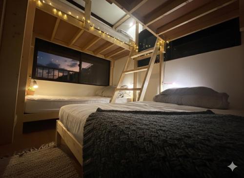a bedroom with two bunk beds and a window at MACARA Guesthouse in Nichinan