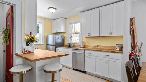 a kitchen with white cabinets and a wooden counter top at Alpine Adventure in Red Lodge