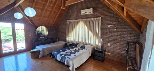 a bedroom with two beds and a brick wall at Chalet Nuevo Amanecer in Merlo