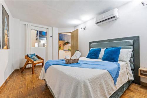 a bedroom with a large bed with blue pillows at Casa Payis Hotel in Cartagena de Indias