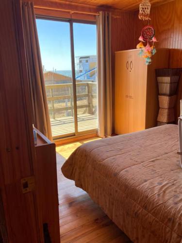 a bedroom with a bed and a large window at Cómoda Casa Con Vista al Mar in El Cerrillo