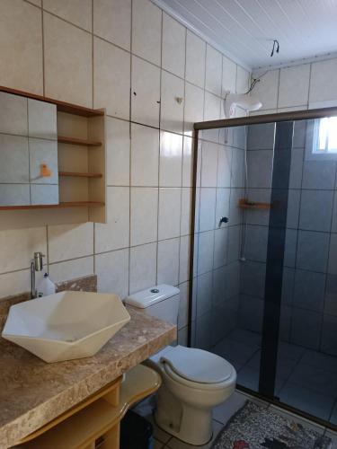 a bathroom with a toilet and a shower and a sink at Casa de 1 quarto in Torres