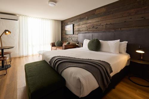 a bedroom with a large bed with a wooden wall at Mercure Barossa Valley in Tanunda