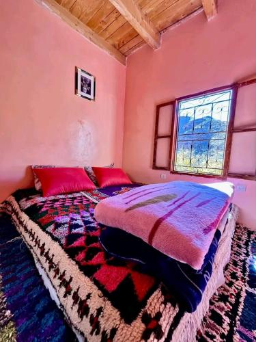 a bedroom with a bed and a window in it at Gîte Chez habitant in Telouet