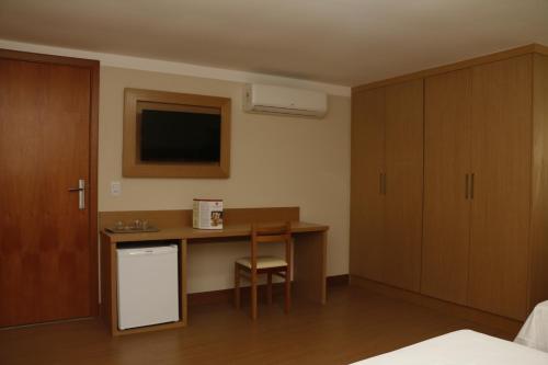 a hotel room with a desk and a tv at Hotel Pouso Real in Rio de Janeiro