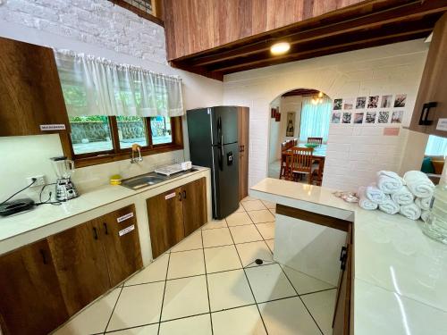 une cuisine avec un réfrigérateur noir et un évier dans l'établissement Casa de Emmita, à Puyo