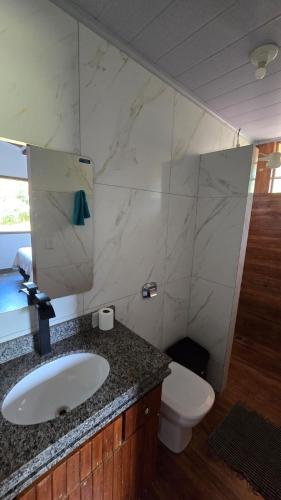 a bathroom with a sink and a toilet at Excelente Sitio em Juatuba in Juatuba
