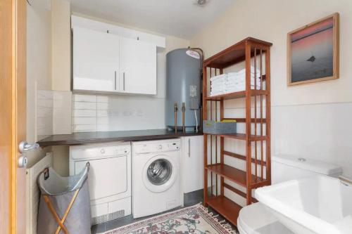 a laundry room with a washer and dryer at Spectacular 2 Bedroom Apartment with Sunny Garden & Terrace in Dublin